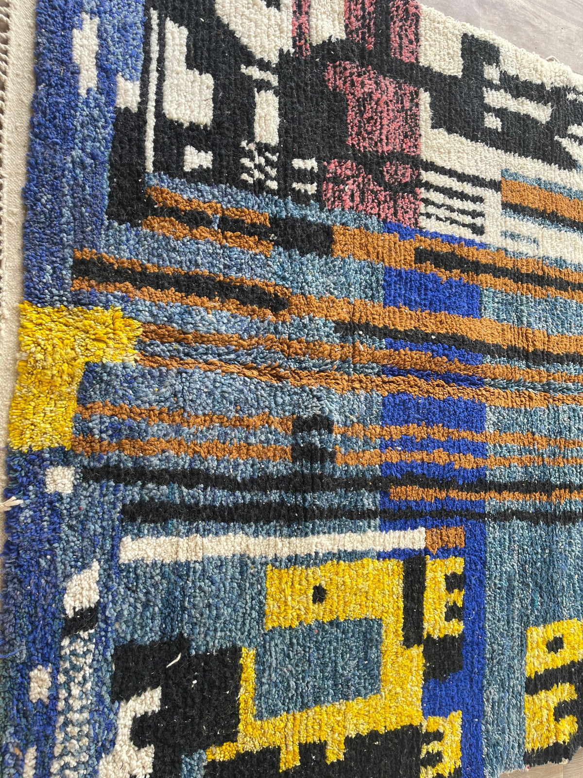 Gros plan sur un détail du tapis berbère Marchica, nuances de la laine et du motif de près