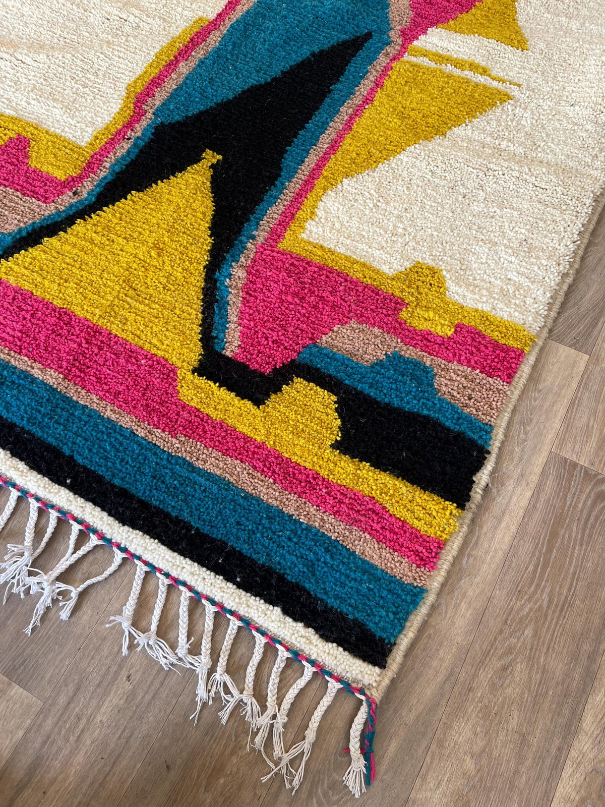 Gros plan sur le coin relevé du tapis berbère Dourzal, épaisseur du poil moyen et dos tissé à la main