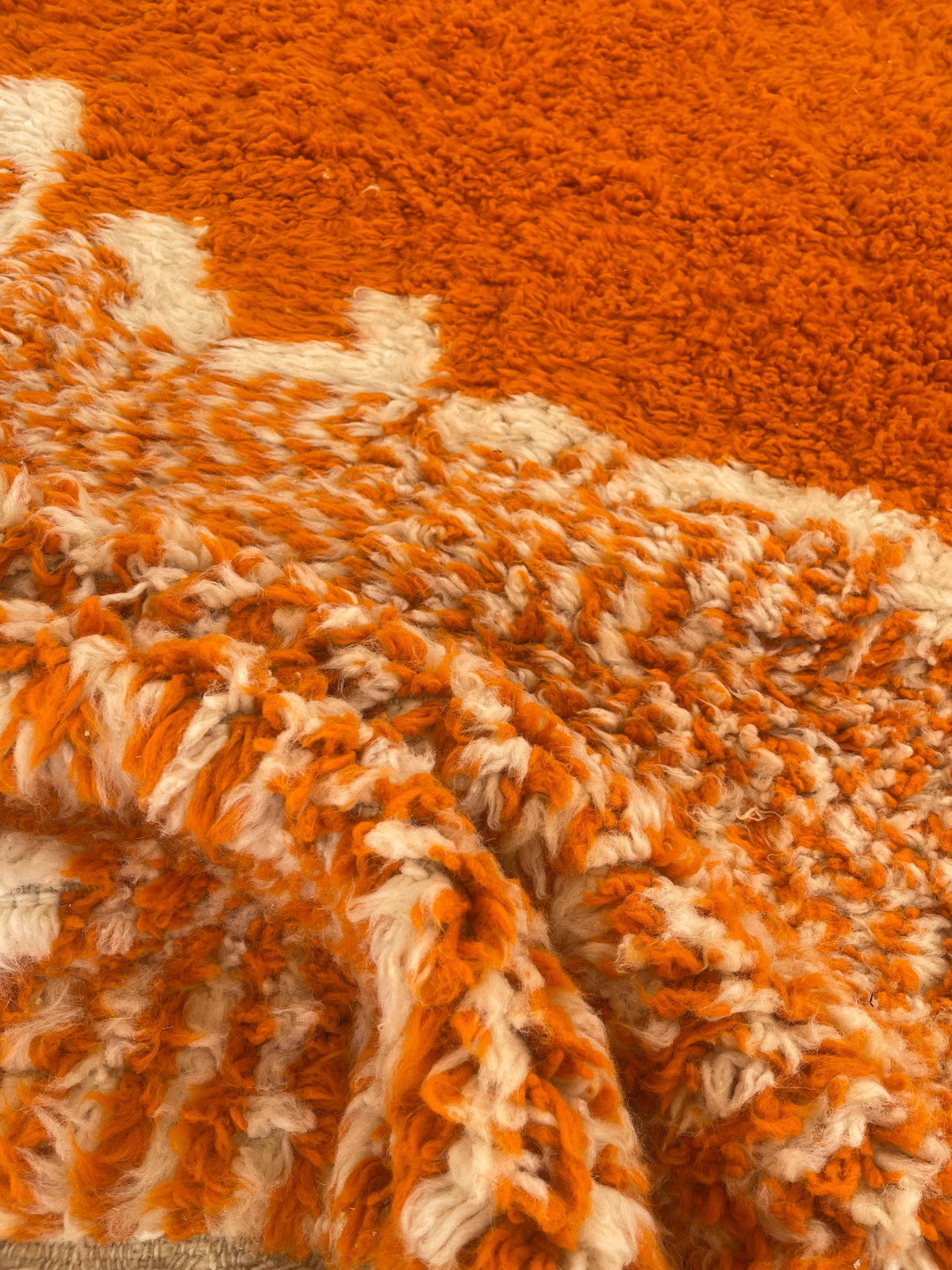 Close-up of the wool of the Azghal Berber rug, long-pile sheep's wool in orange and white