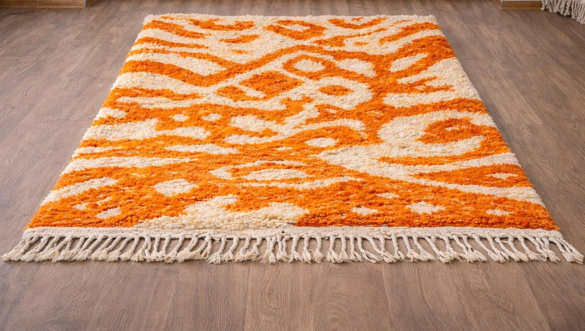 Todgha colourful Berber rug in orange and white, on the floor, seen from the side at an angle, hand-knotted in Morocco