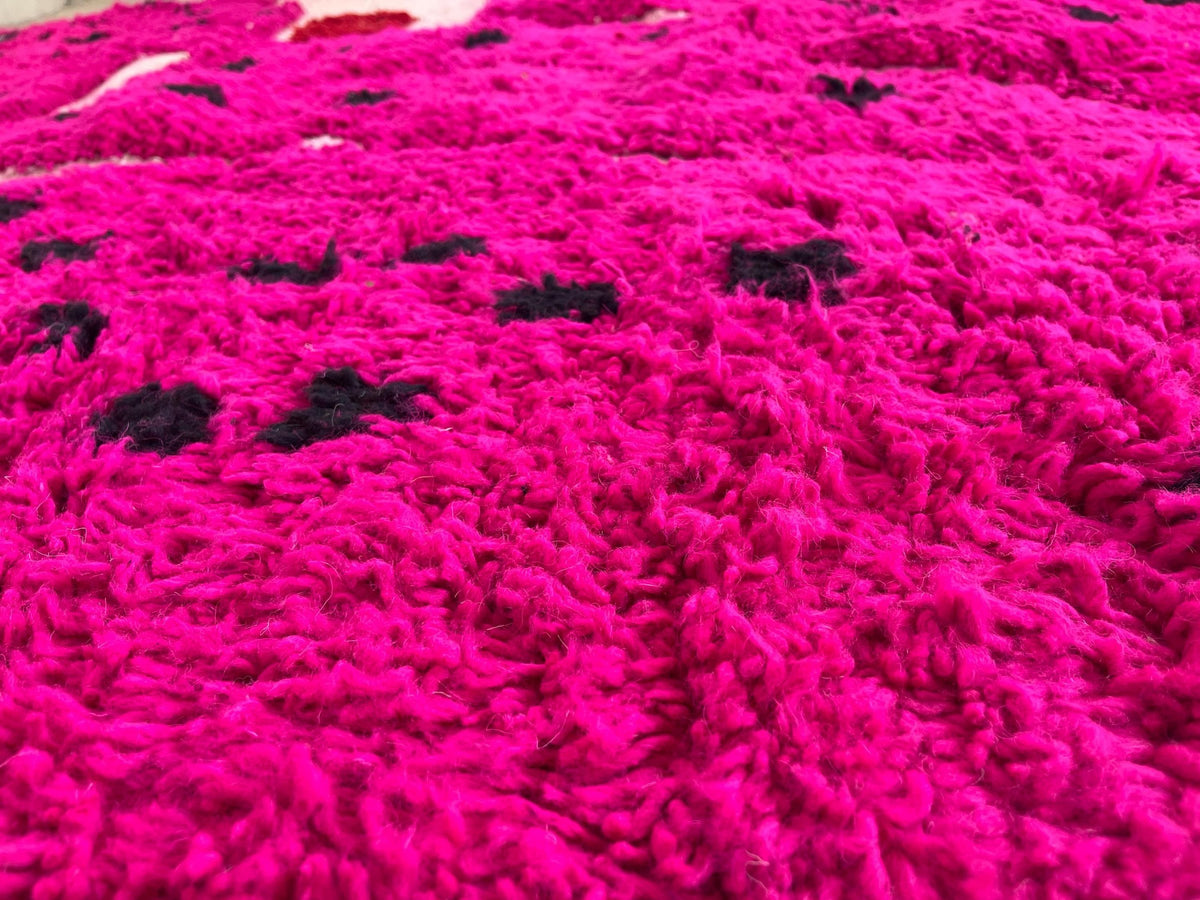 Gros plan sur la laine du tapis berbère Iriki, nœuds serrés et tracé du motif de près