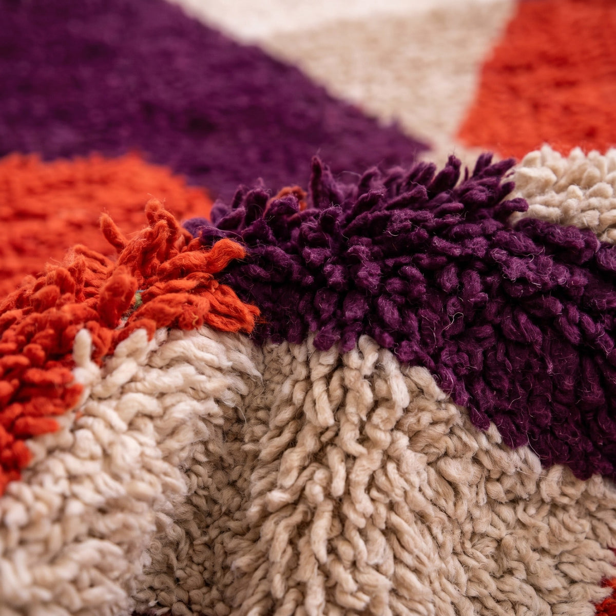 Gros plan sur un motif du tapis berbère Alnif, blocs géométriques imbriqués sans bordure, rouge brique dominant