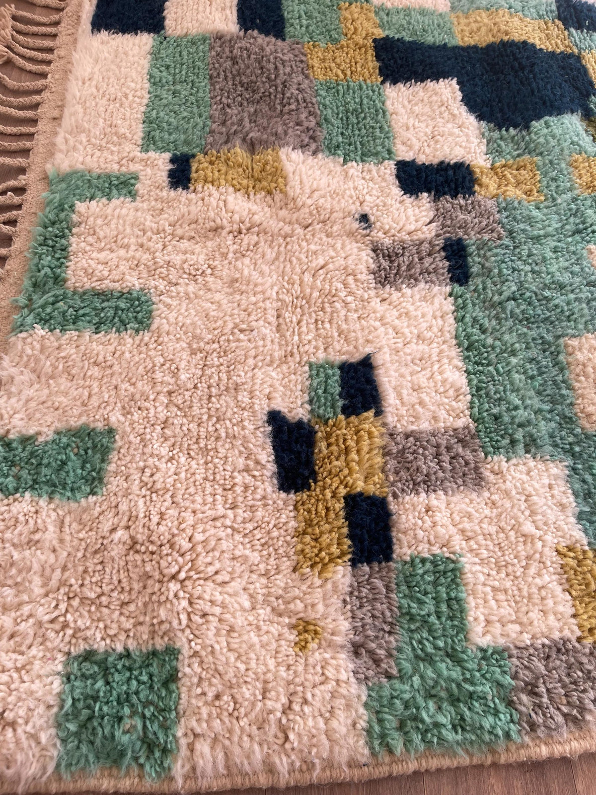Gros plan sur un détail du tapis berbère Tessaout, tracé irrégulier du motif fait main