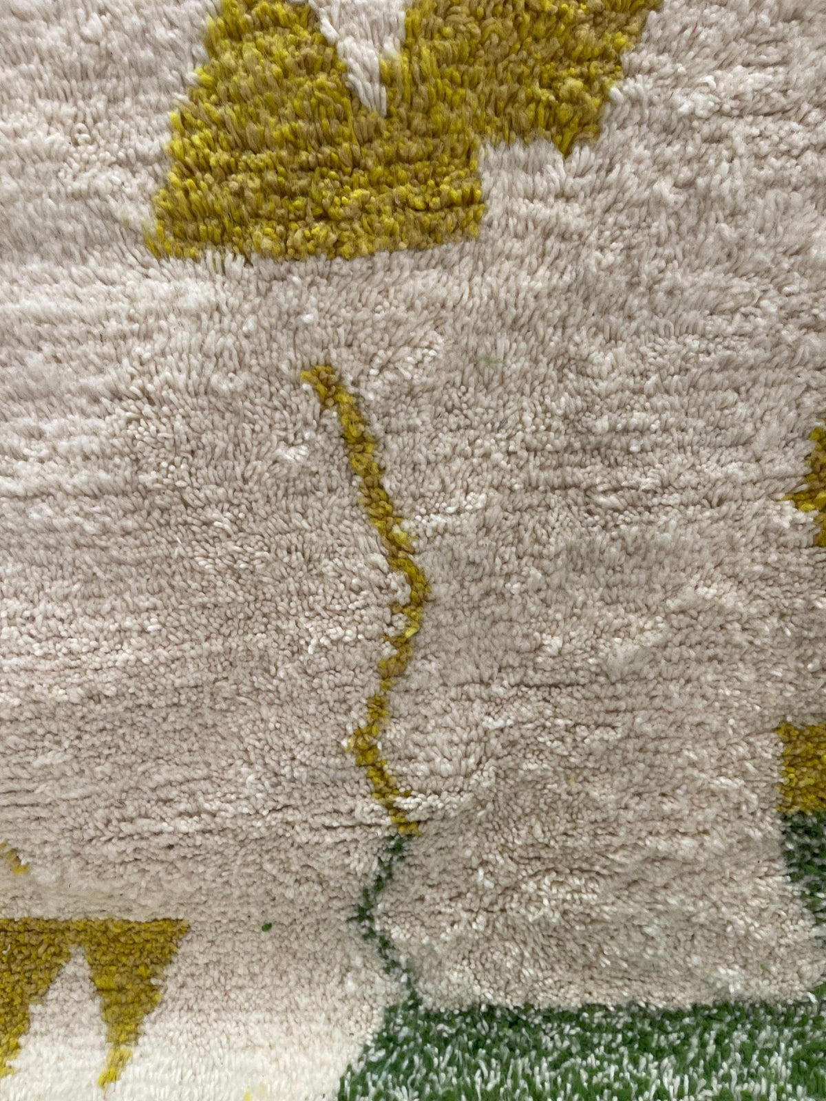 Gros plan sur la laine du tapis berbère Tounfite, nœuds serrés et tracé du motif de près