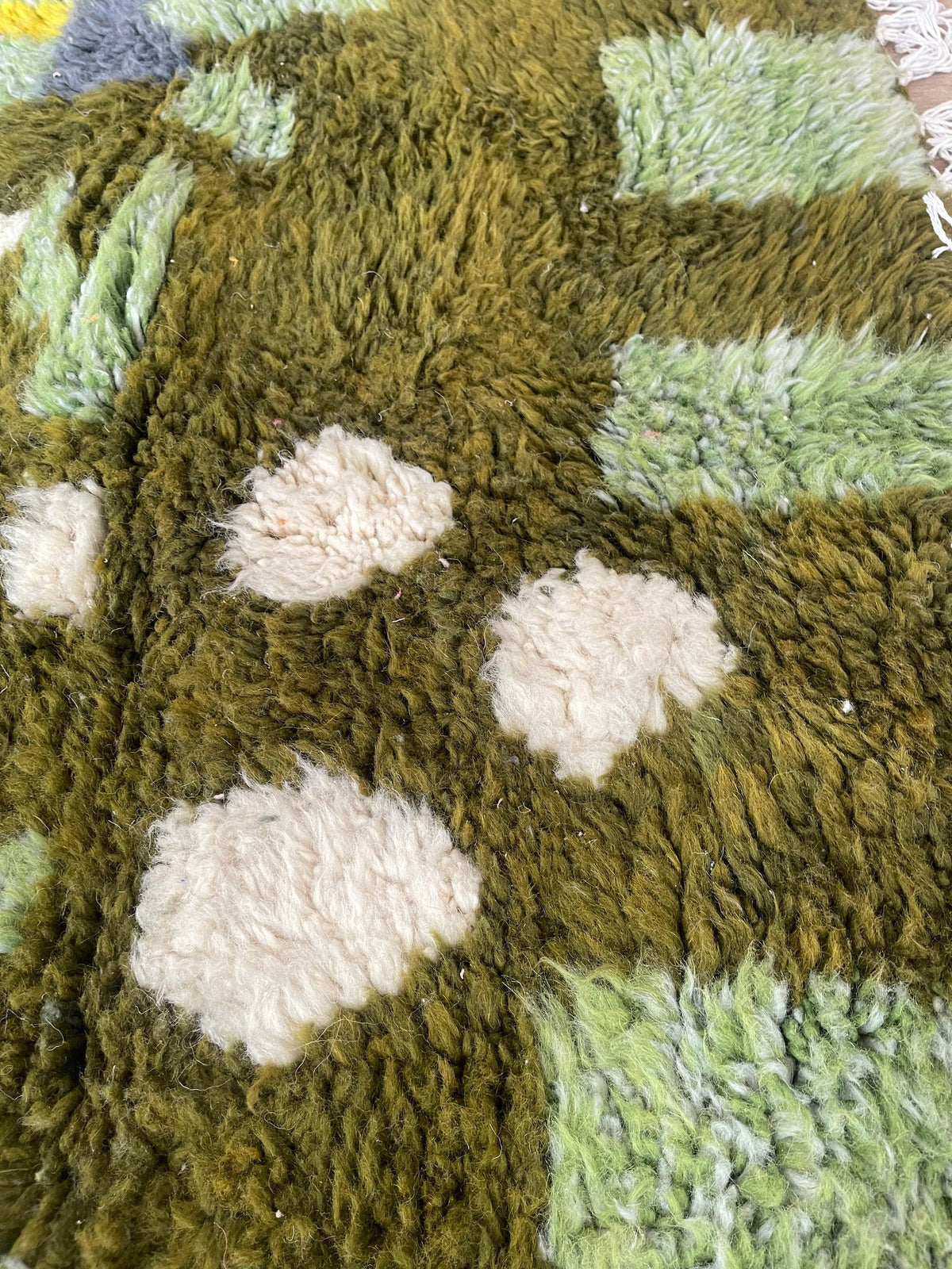 Gros plan sur la laine du tapis berbère Aoufous, texture de la laine naturelle et nuances du poil
