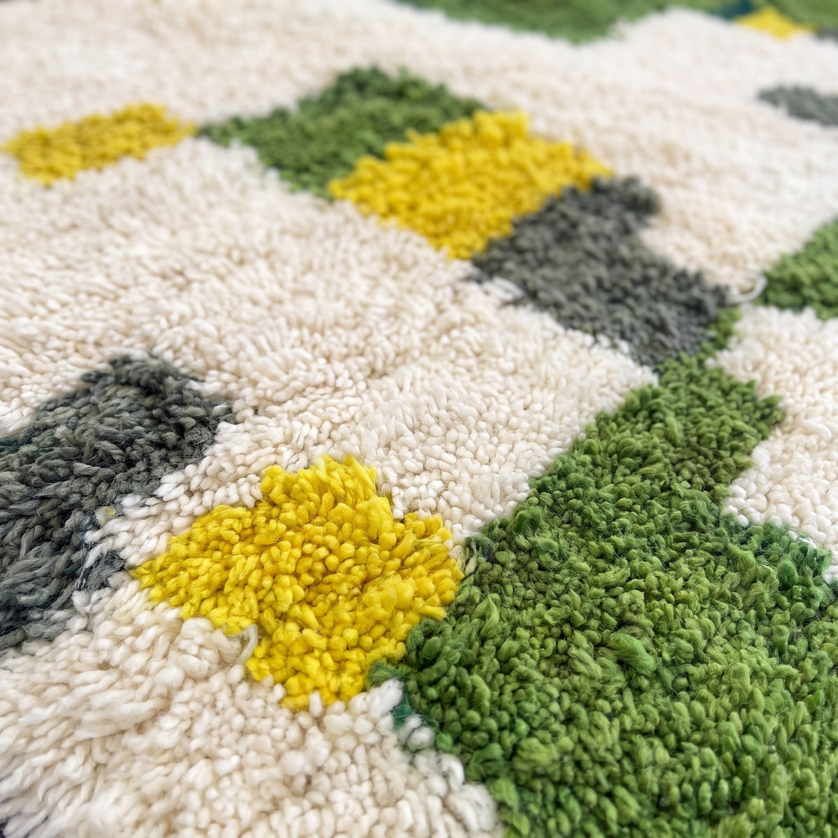 Gros plan sur un motif du tapis berbère Zegzel, patchwork irrégulier, moitié haute ivoire semée
