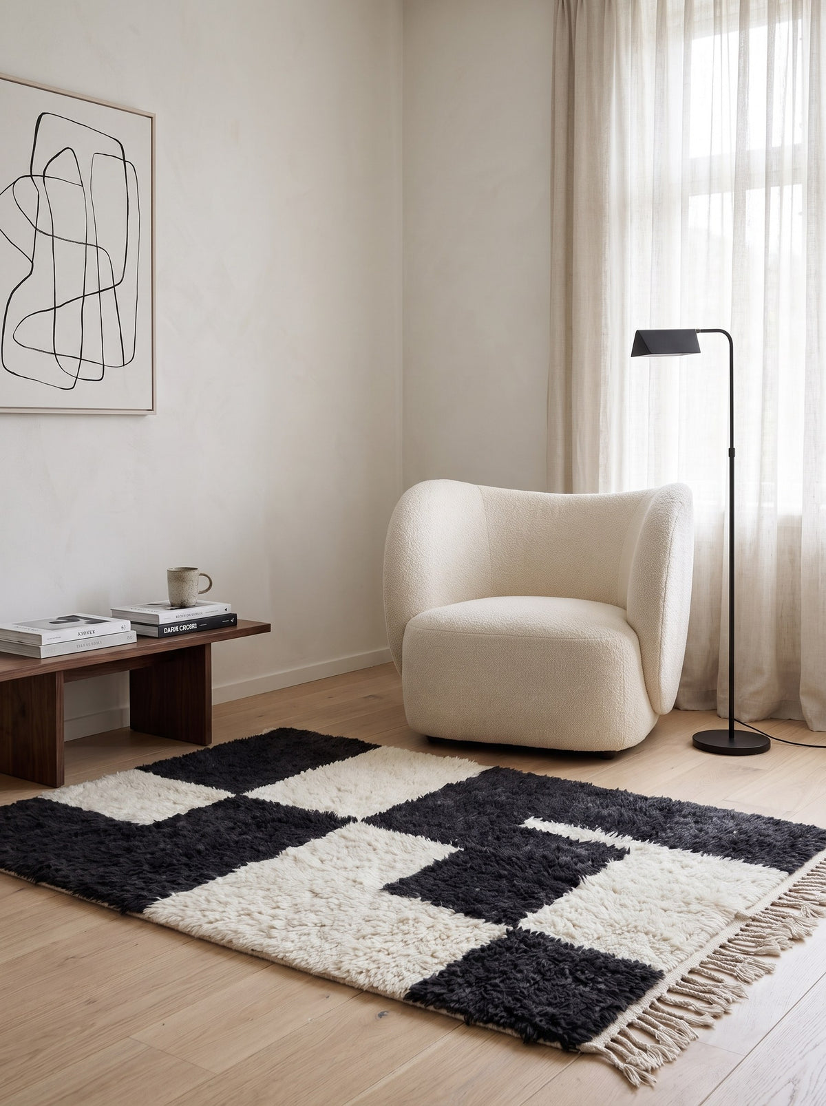 Tapis berbère damier anthracite et blanc Bani dans un coin lecture, noué main au Maroc