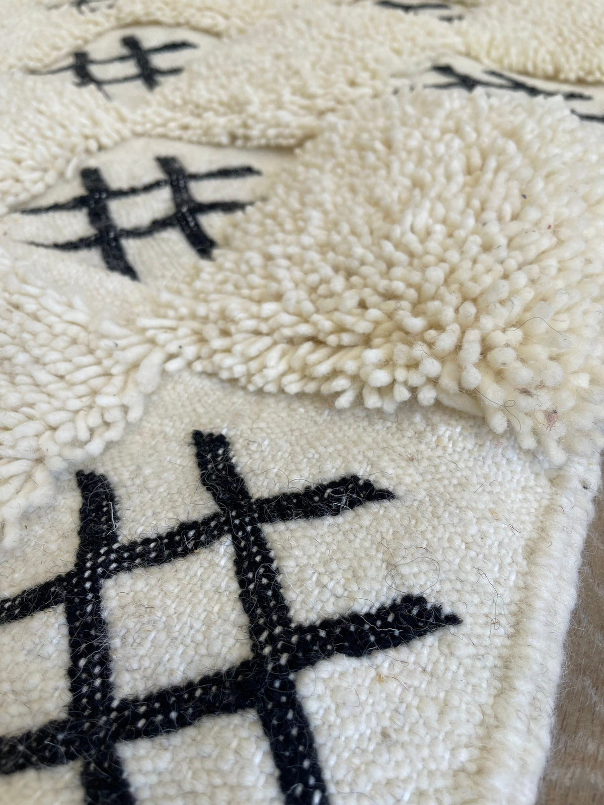 Gros plan sur la laine du tapis berbère Ouaneskra, texture de la laine naturelle et nuances du poil