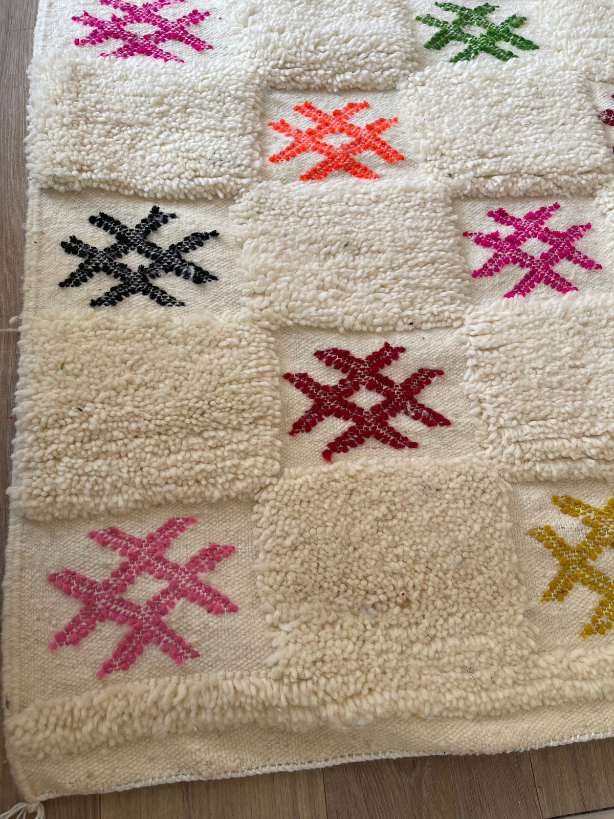 Gros plan sur le coin relevé du tapis berbère Selbira, épaisseur du poil moyen et dos tissé à la main