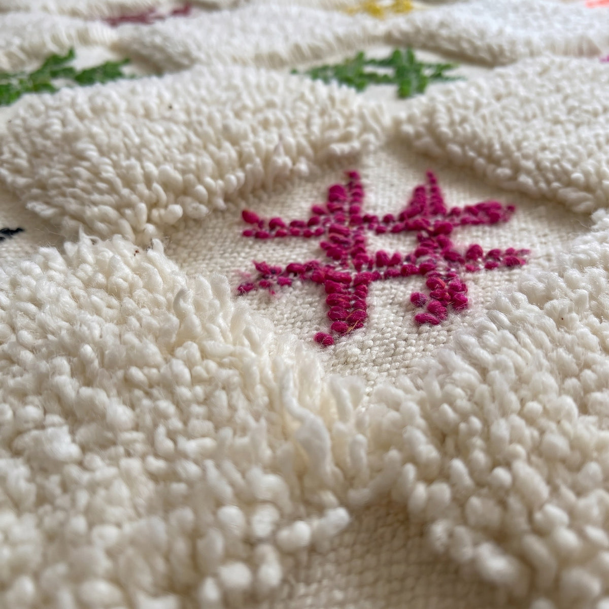 Gros plan sur un motif du tapis berbère Selbira, damier écru d'environ huit carreaux de large