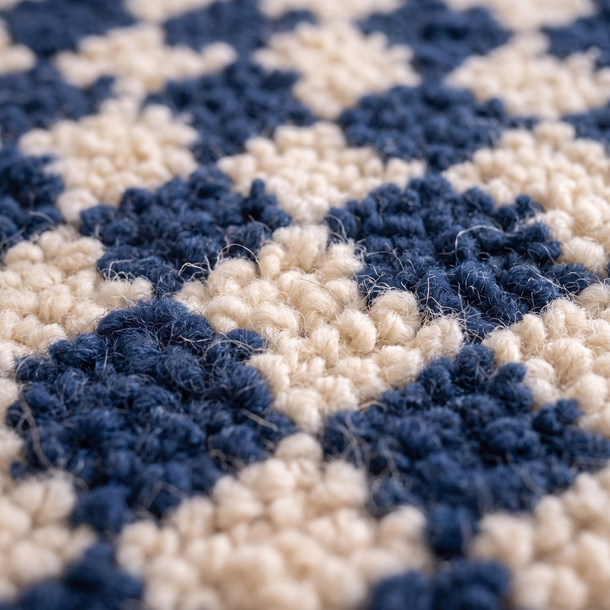 Gros plan sur un motif du tapis berbère Dayet, petit damier irrégulier bleu marine et écru