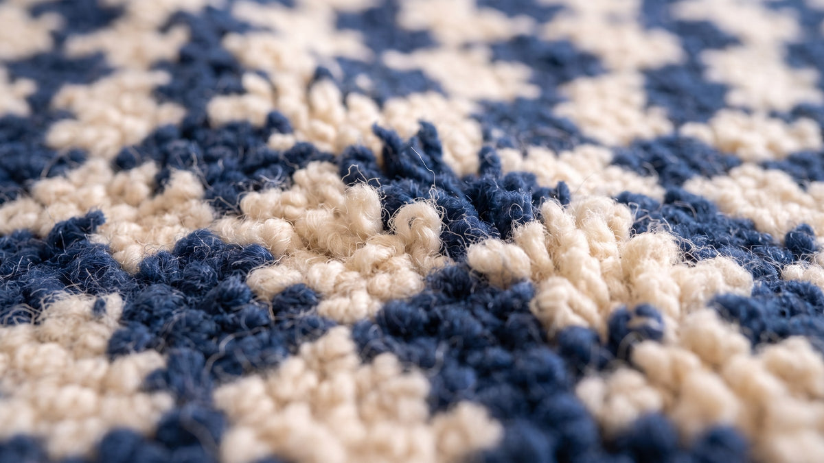 Gros plan sur la laine du tapis berbère Dayet, poil bleu marine noué à la main