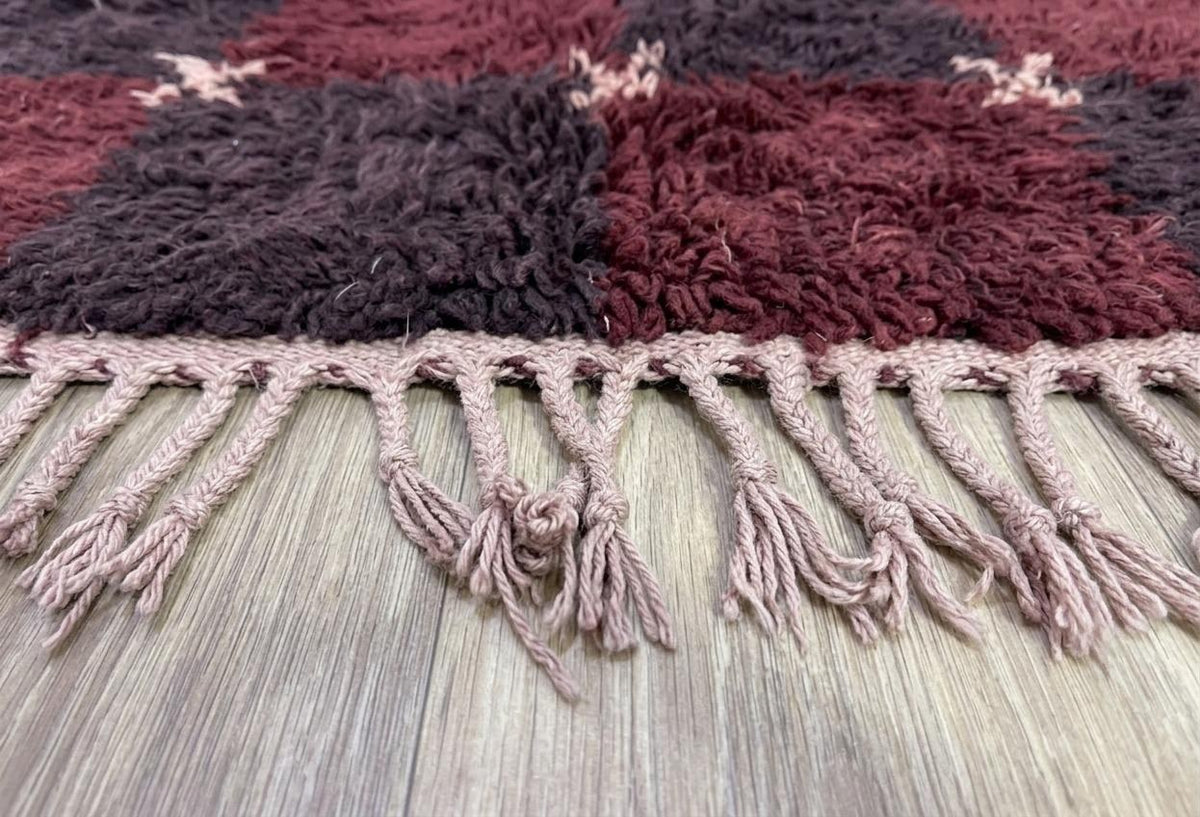 Gros plan sur les franges du tapis berbère Tarwiza, vieux rose nouées, nouées à la main
