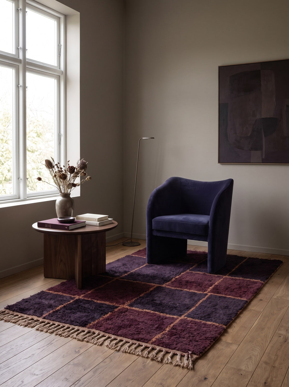 Tapis berbère damier bordeaux et prune Tazgurt dans un coin lecture, noué main au Maroc