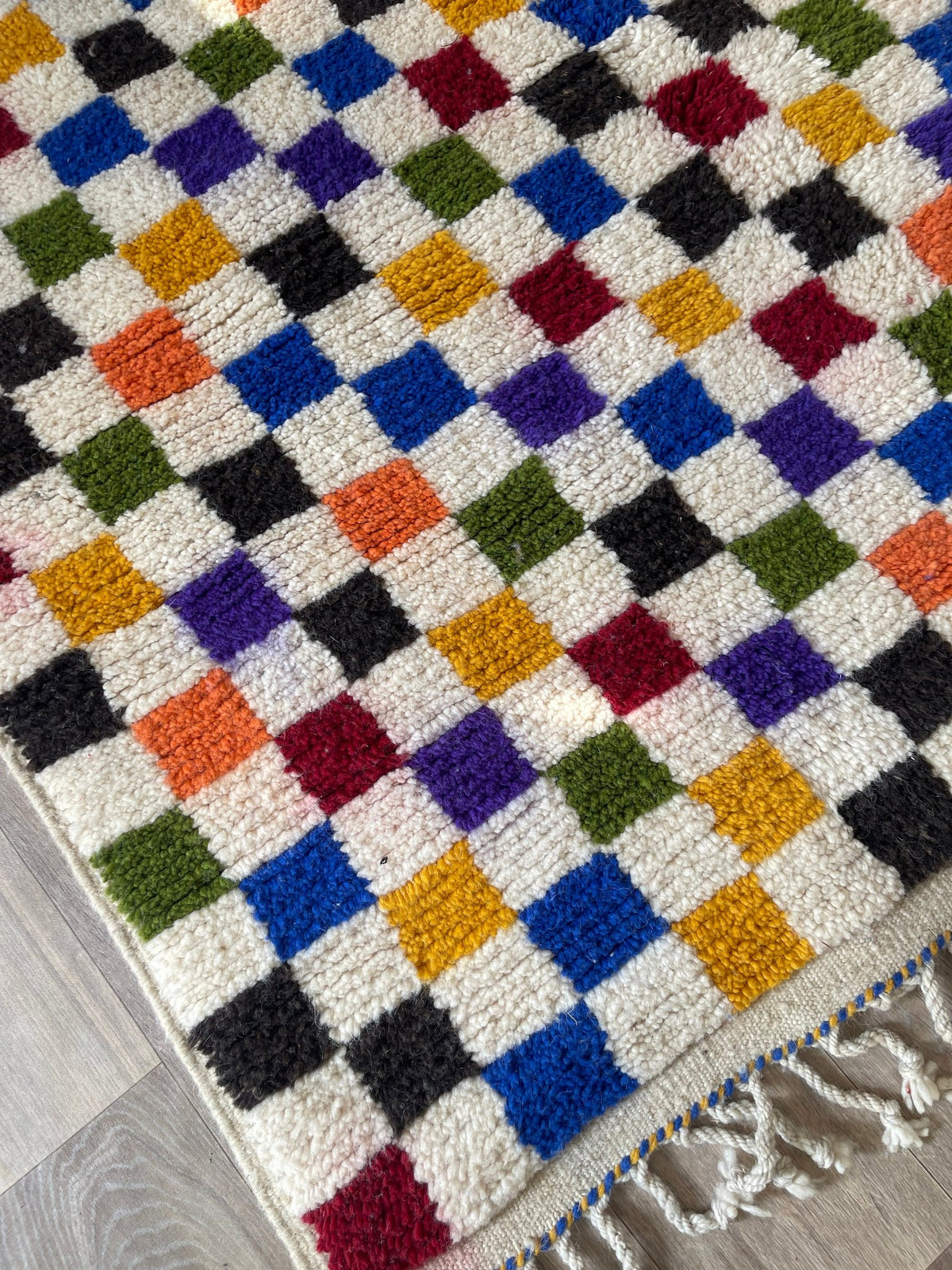 Gros plan sur le coin relevé du tapis berbère Kaldin, épaisseur du poil moyen et dos tissé à la main