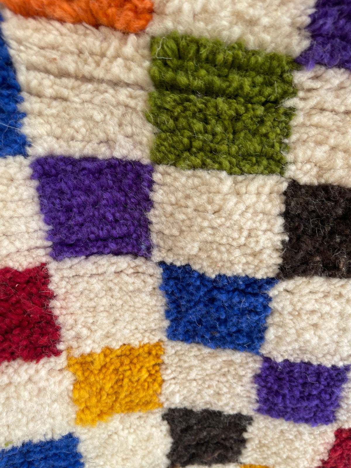 Gros plan sur la laine du tapis berbère Kaldin, nœuds serrés et tracé du motif de près