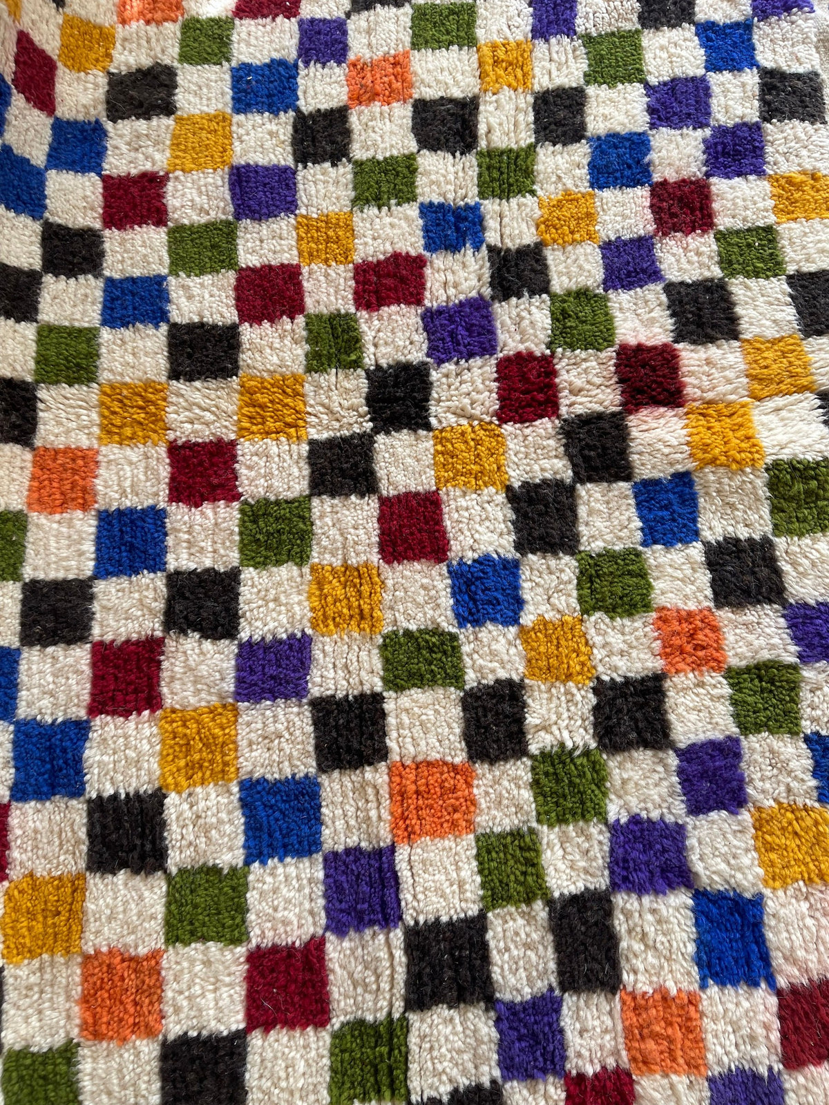 Gros plan sur un détail du tapis berbère Kaldin, poil moyen et motif multicolore vus de près