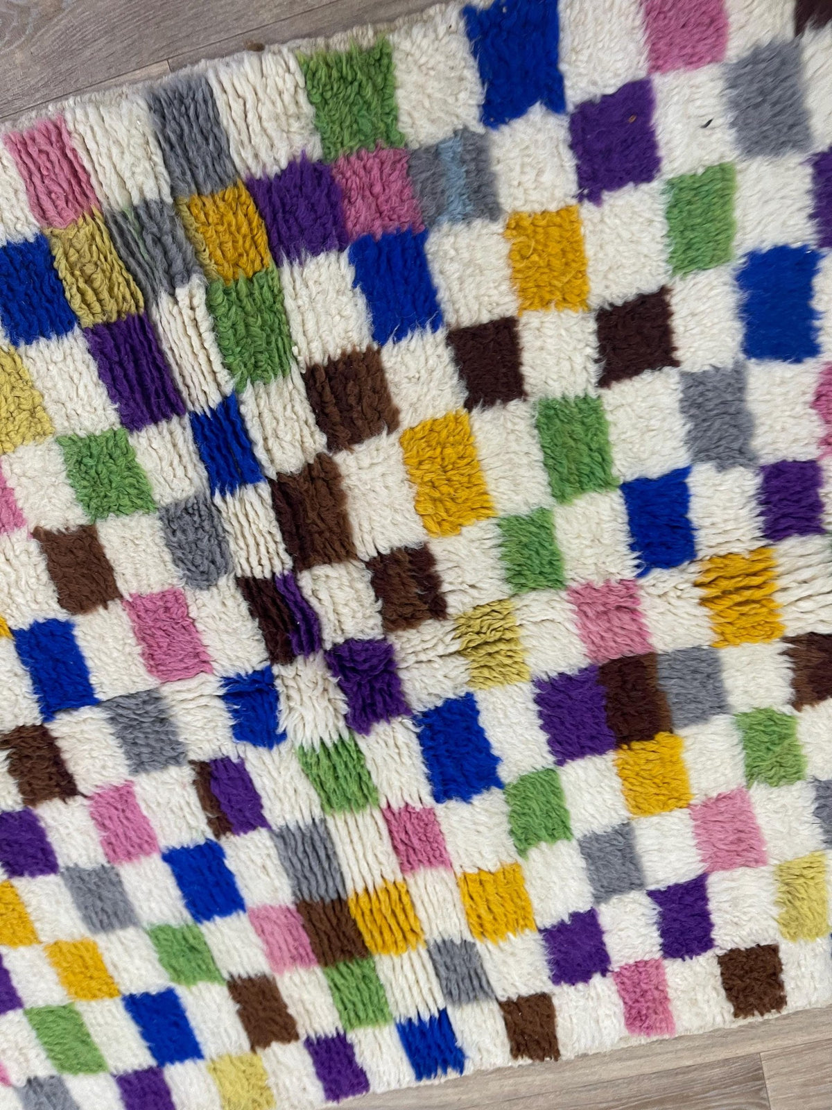Gros plan sur la laine du tapis berbère Mokrisset, laine de mouton au poil moyen, multicolore