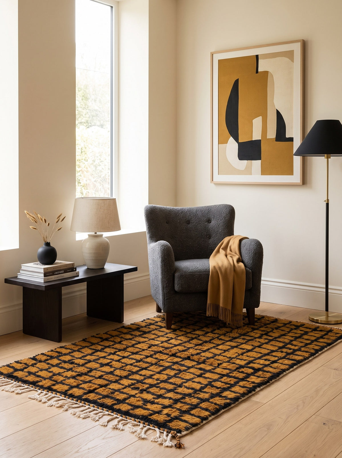 Tapis berbère damier ocre et noir Tirgamt dans un coin lecture, noué main au Maroc