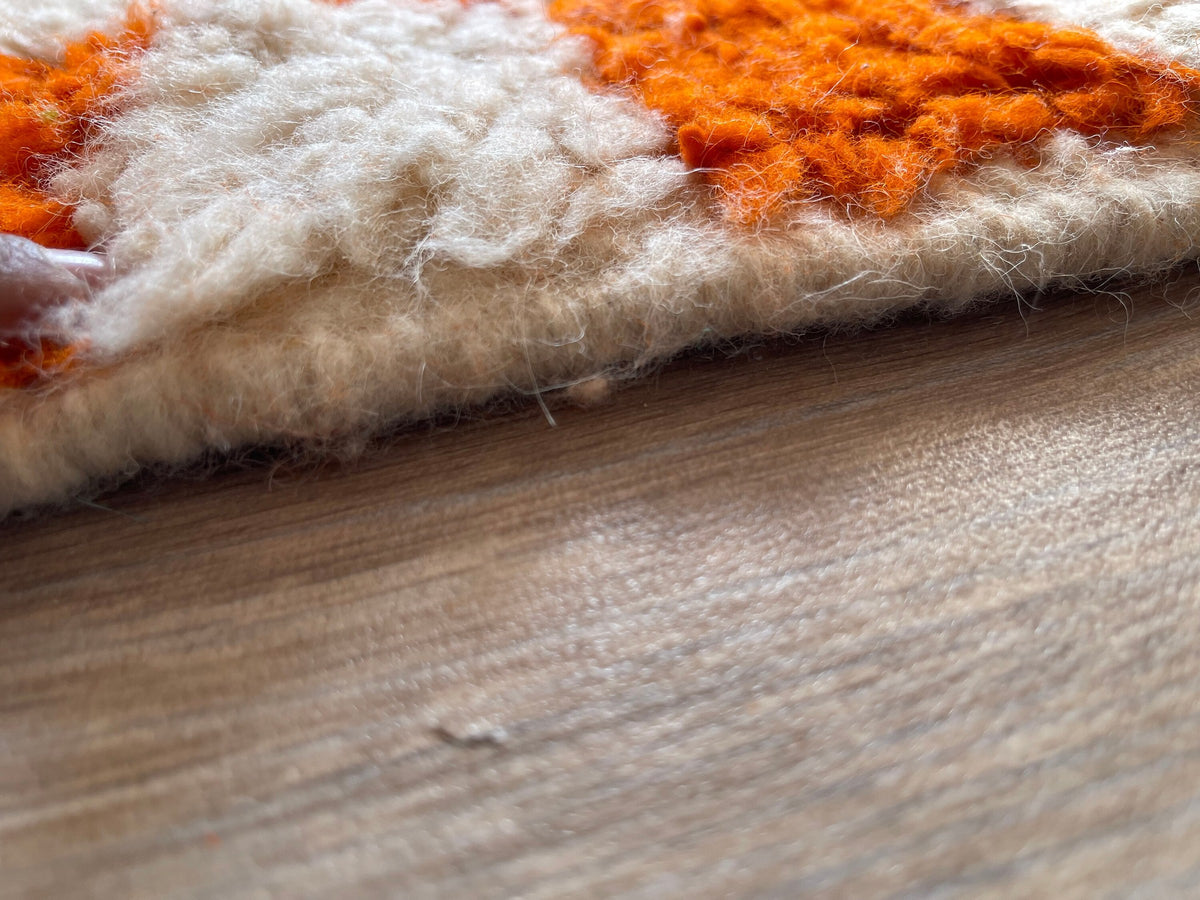 Close-up of the turned-up corner of the Ouzina Berber rug, long pile depth and hand-woven back