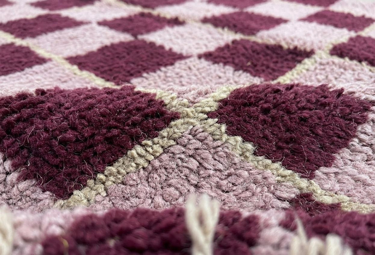 Gros plan sur la laine du tapis berbère Timerza, nœuds serrés et tracé du motif de près