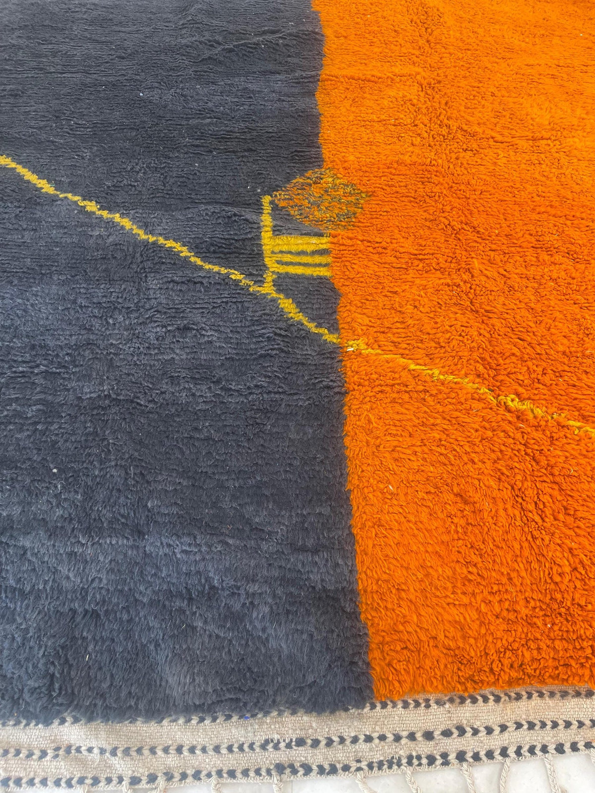 Close-up of the wool of the Fezouata Berber rug, long-pile sheep's wool, charcoal and orange