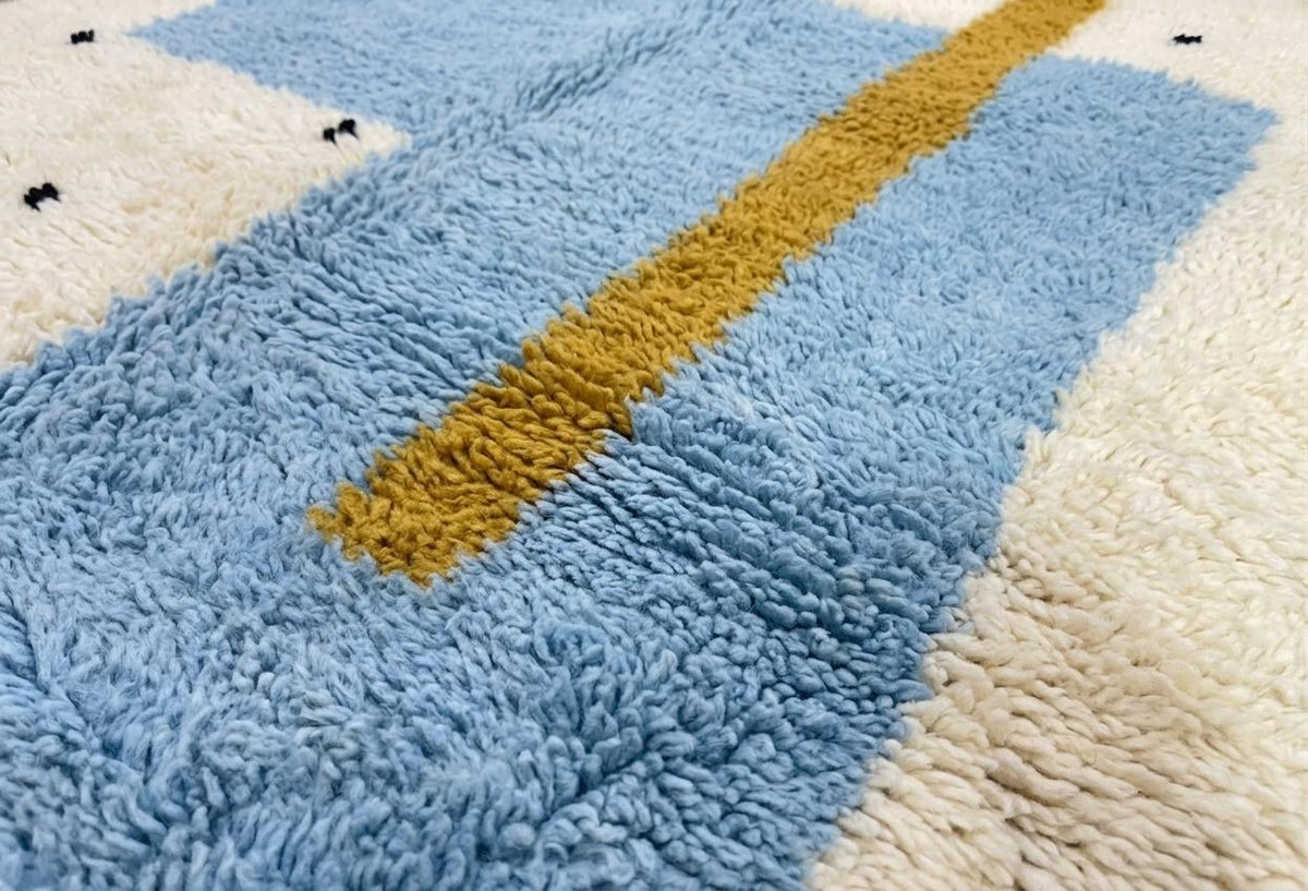 Gros plan sur la laine du tapis berbère Tazmir, laine de mouton au poil long, blanche et bleu ciel