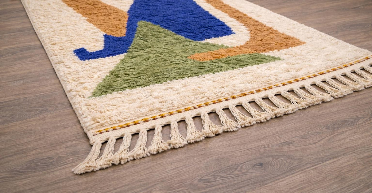 Tapis berbère graphique blanc et bleu roi Targit posé au sol vu en biais, noué main au Maroc