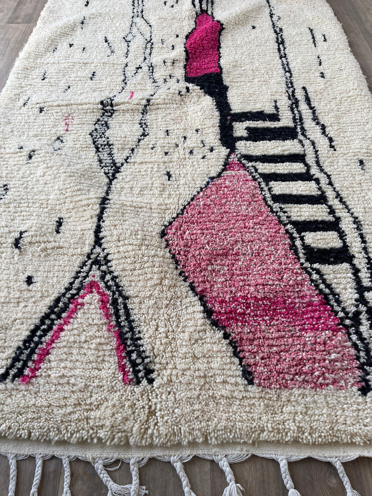 Gros plan sur les franges du tapis berbère Tira, écrues, nouées à la main