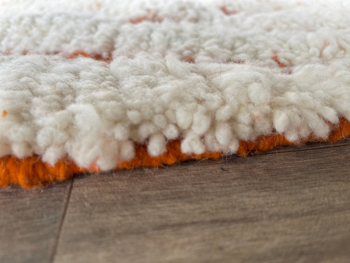 Close-up of the turned-up corner of the Igdat Berber rug, thickness of the long pile and hand-woven back