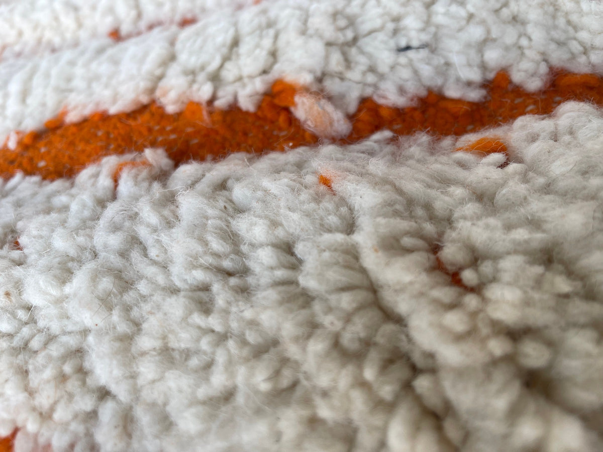 Close-up of the wool of the Igdat Berber rug, long-pile sheep's wool in white and orange