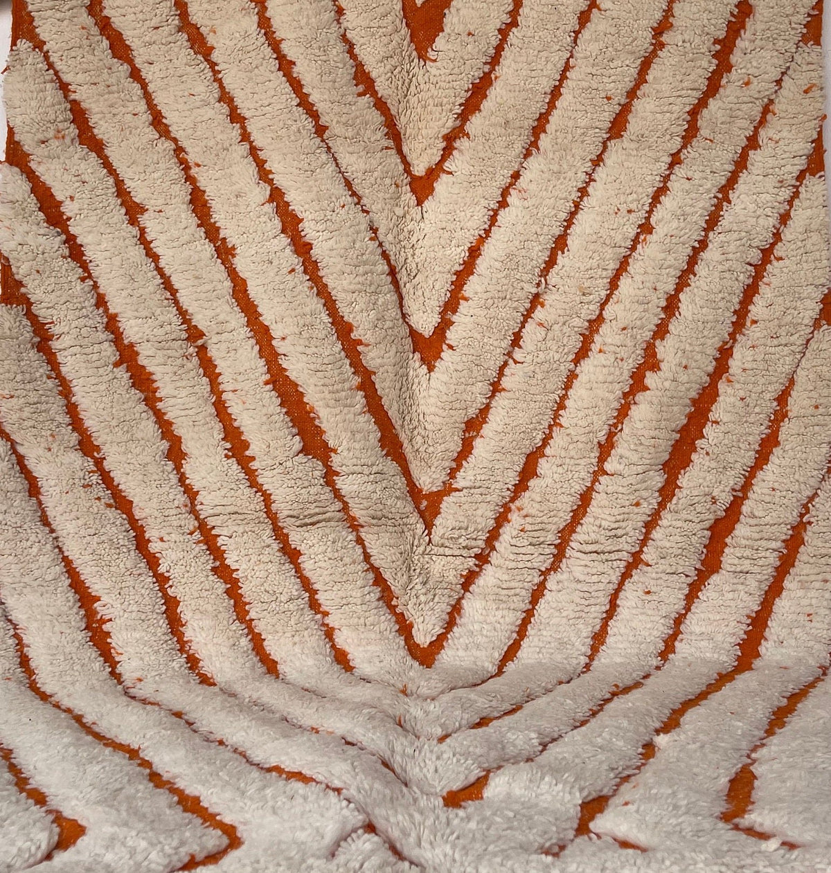 Close-up of a detail on the Igdat Berber rug, long pile and pattern in white and orange up close