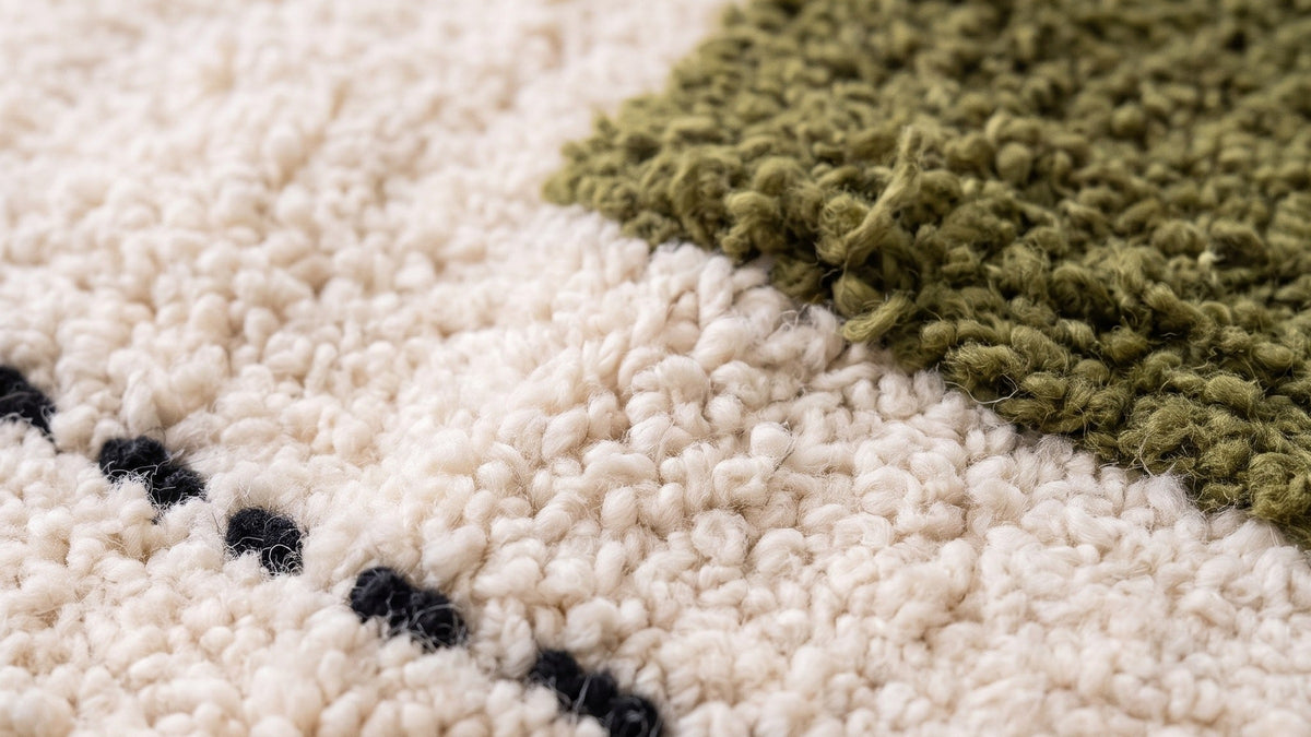 Gros plan sur la laine du tapis berbère Abrid, poil blanc et vert noué à la main