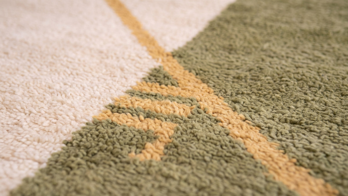 Gros plan sur la laine du tapis berbère Tiflet, poil blanc et vert olive