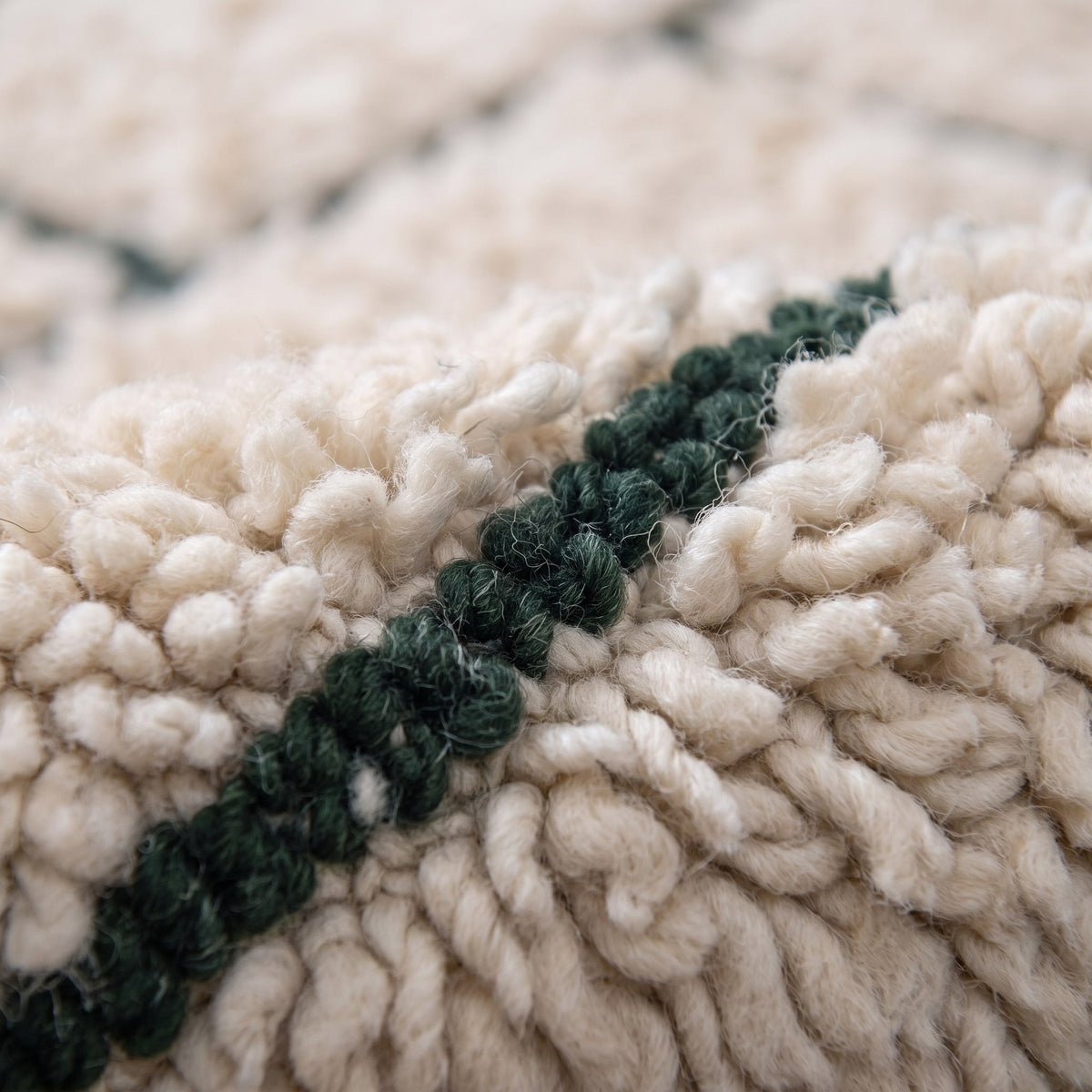 Gros plan sur un motif du tapis berbère Tisent, fond écru, grille de pavés rectangulaires disposés