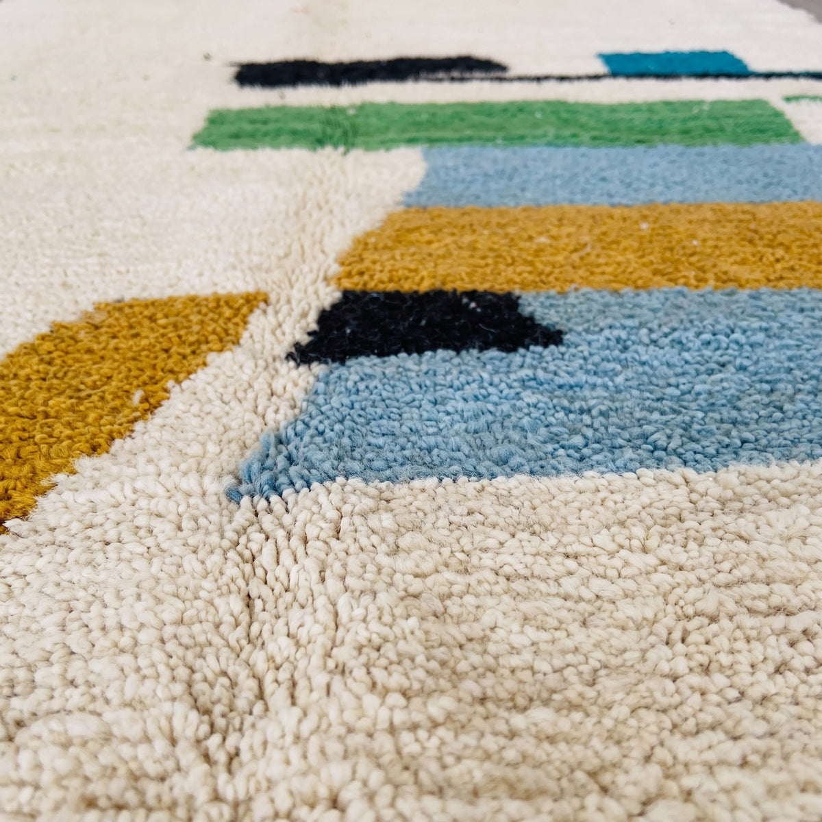 Gros plan sur un motif du tapis berbère Imoulas, champ écru à poil très court