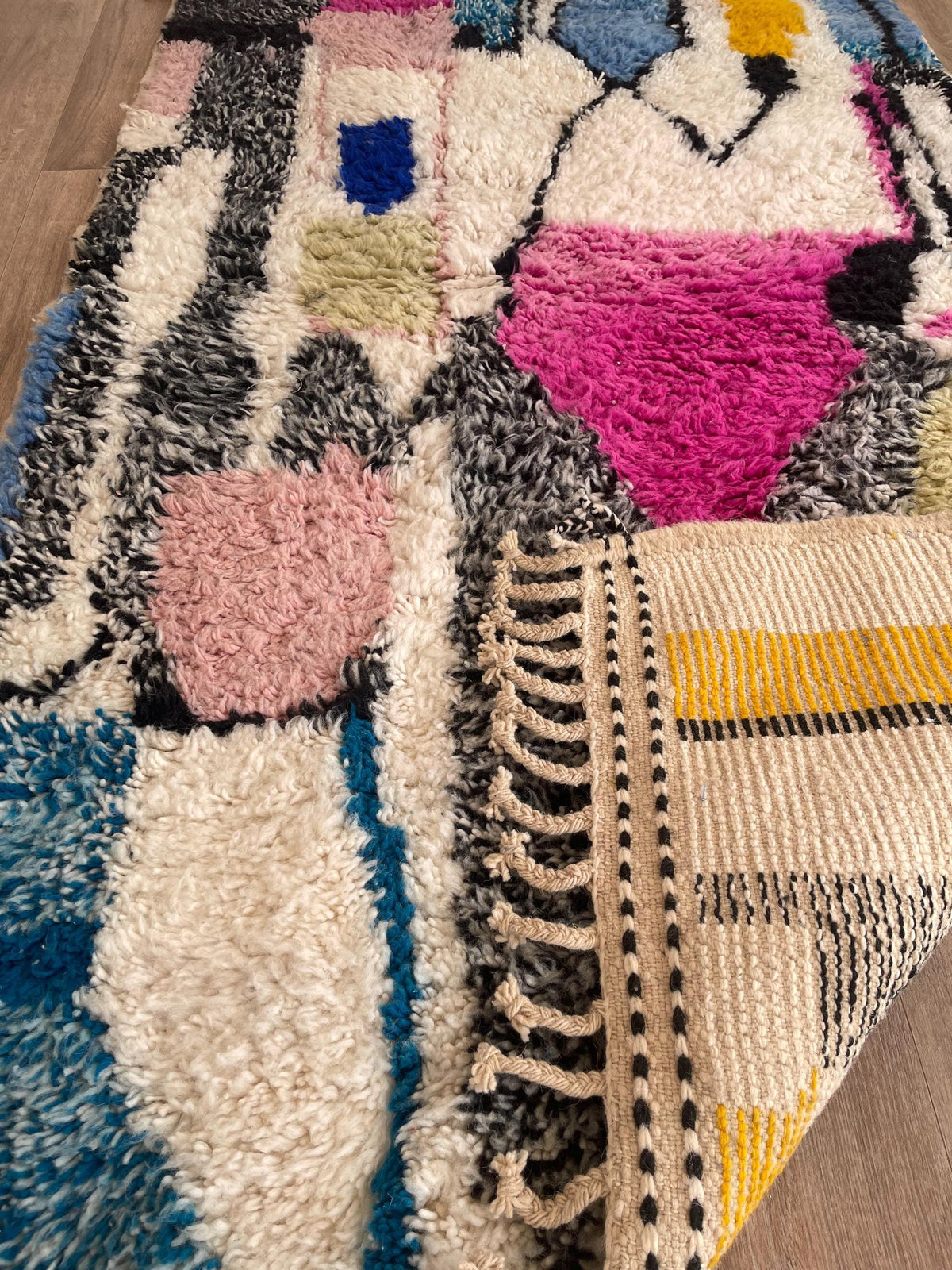 Gros plan sur l'envers du tapis berbère Lozmira, nœuds visibles sur la chaîne de coton, sans dossier