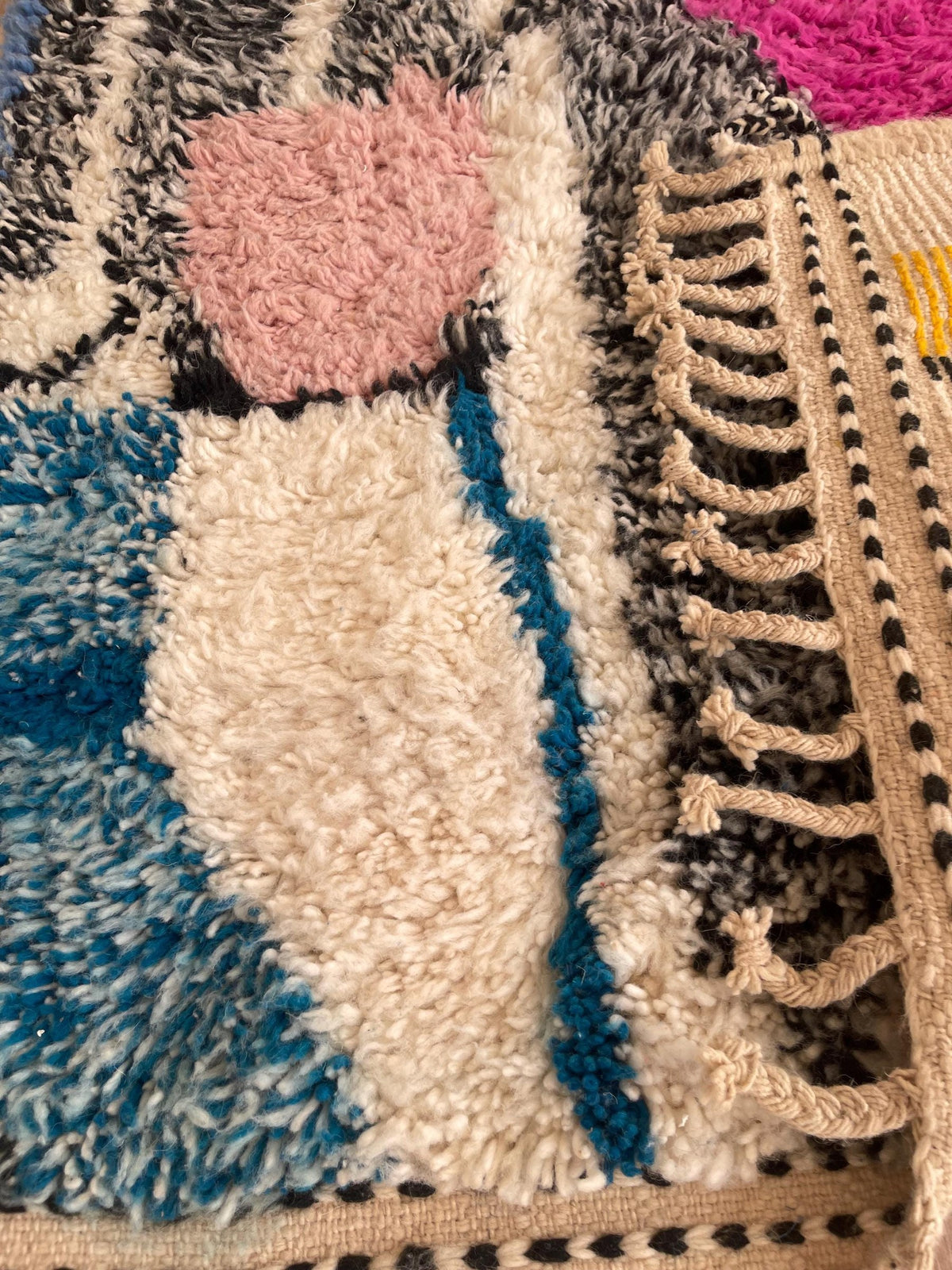 Gros plan sur l'envers du tapis berbère Lozmira, dos tissé qui montre le travail fait main