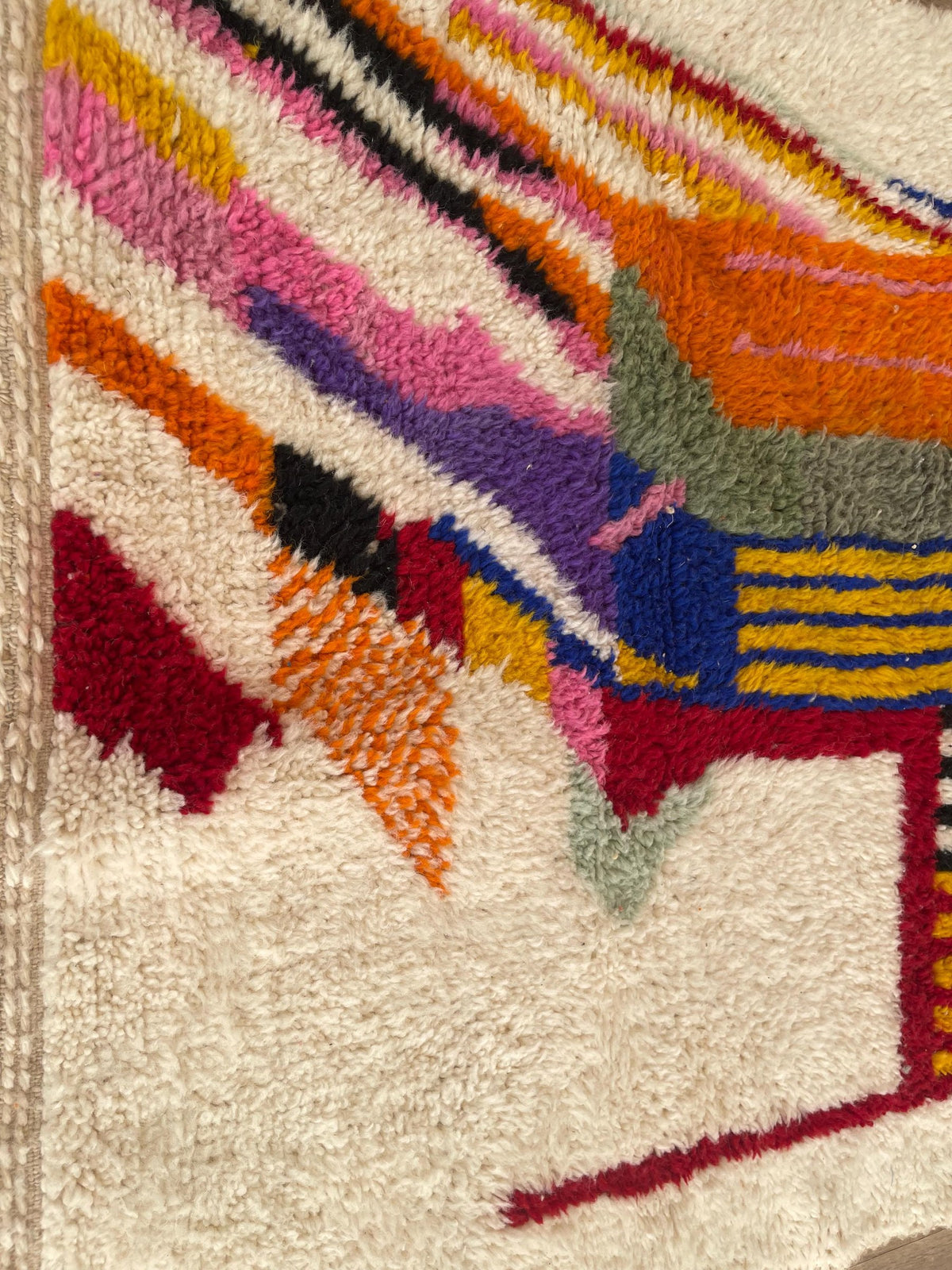 Close-up of a detail on the Tamgrout Berber rug, medium pile and white and multicoloured pattern seen up close