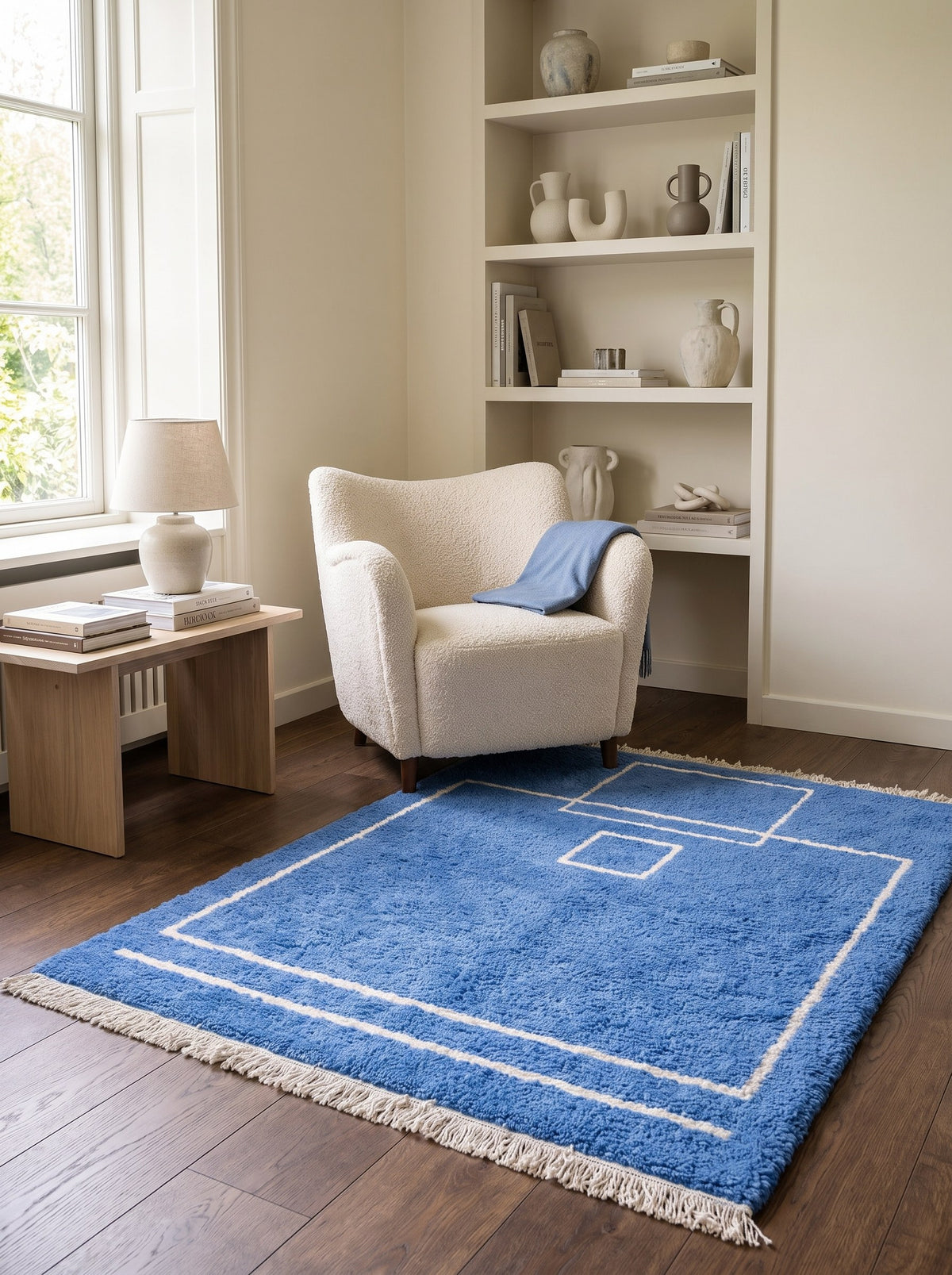 Tapis berbère graphique bleu Amdun dans un coin lecture, noué main au Maroc
