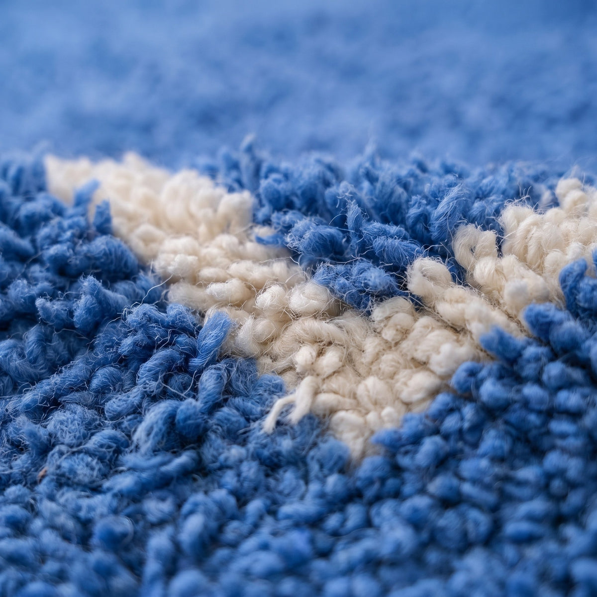 Gros plan sur un motif du tapis berbère Amdun, fond bleu franc à poil moyen