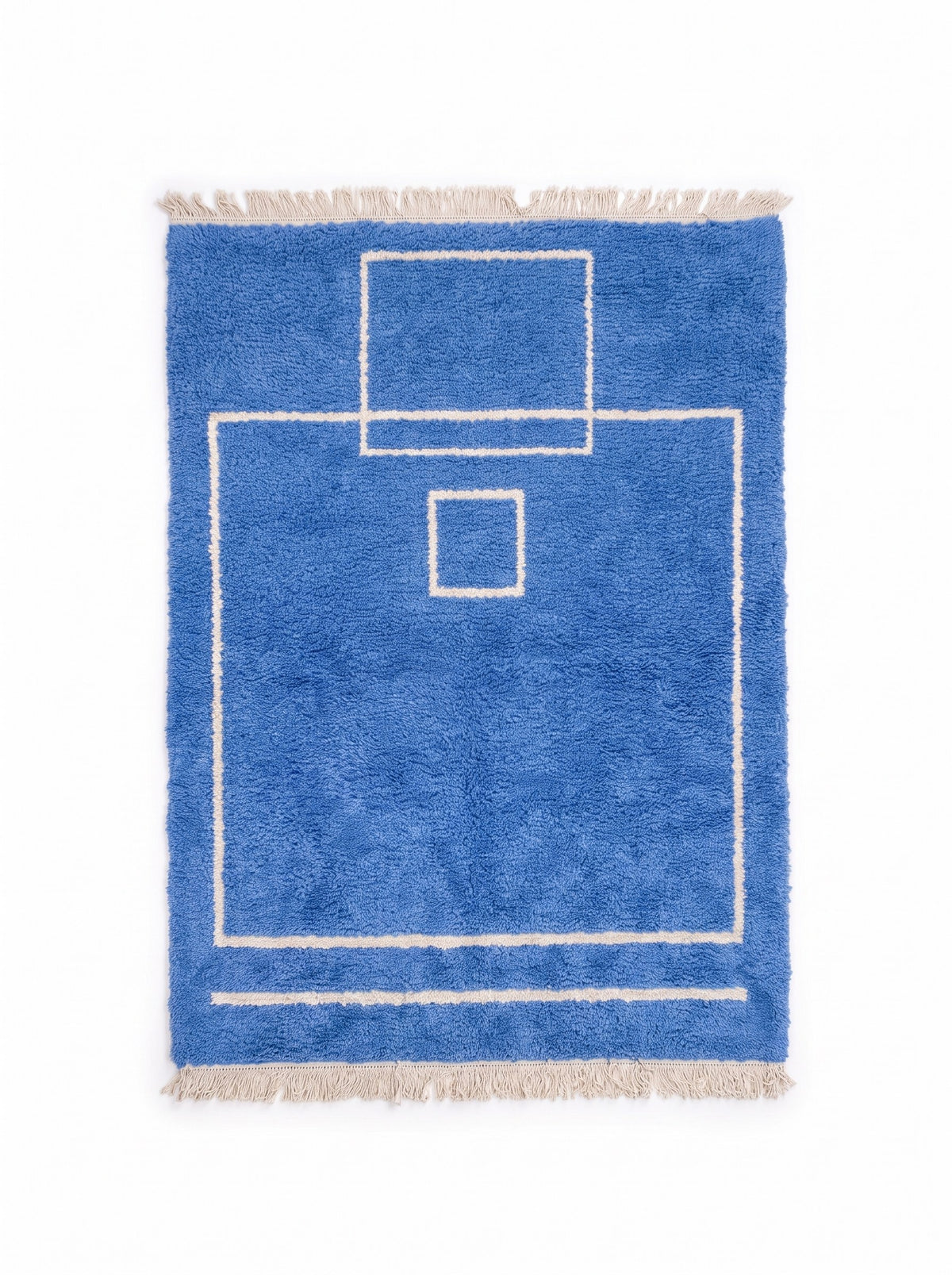 Tapis berbère graphique bleu Amdun vu à plat, fond bleu franc à poil moyen, franges écrues