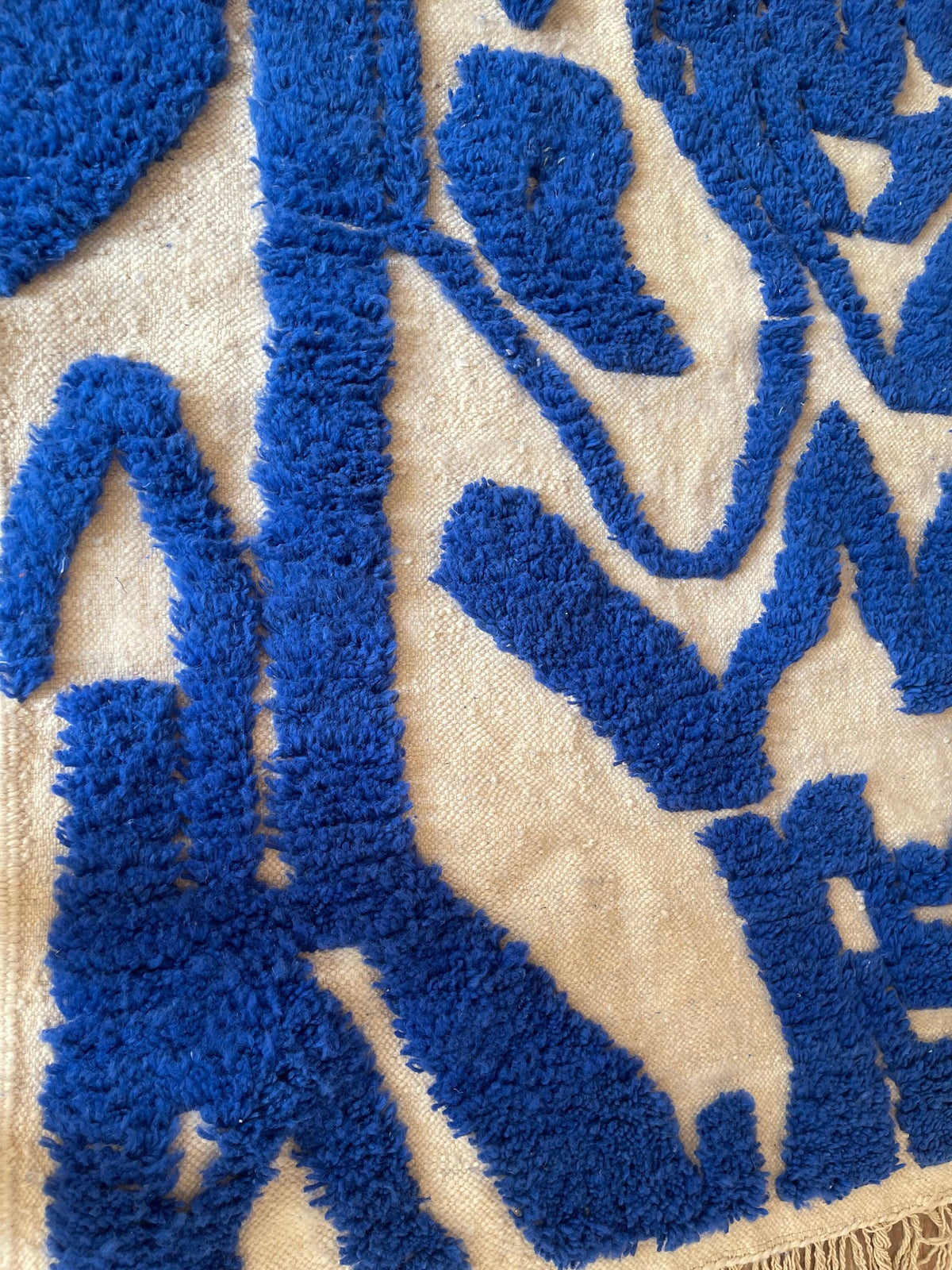Gros plan sur la laine du tapis berbère Isli, texture de la laine naturelle et nuances du poil