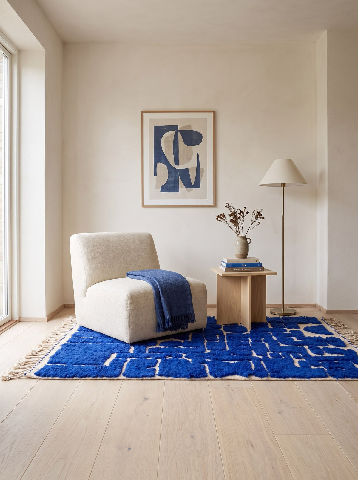 Tapis berbère graphique bleu roi Aghmat dans un coin lecture, noué main au Maroc