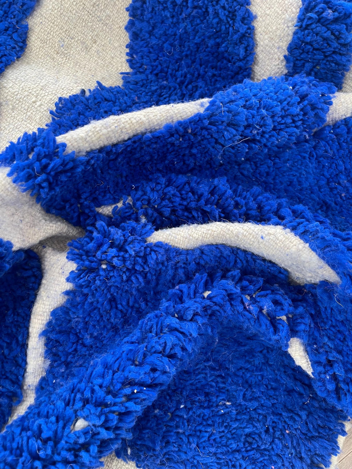 Gros plan sur la laine du tapis berbère Loukkos, laine de mouton au poil long, bleu roi