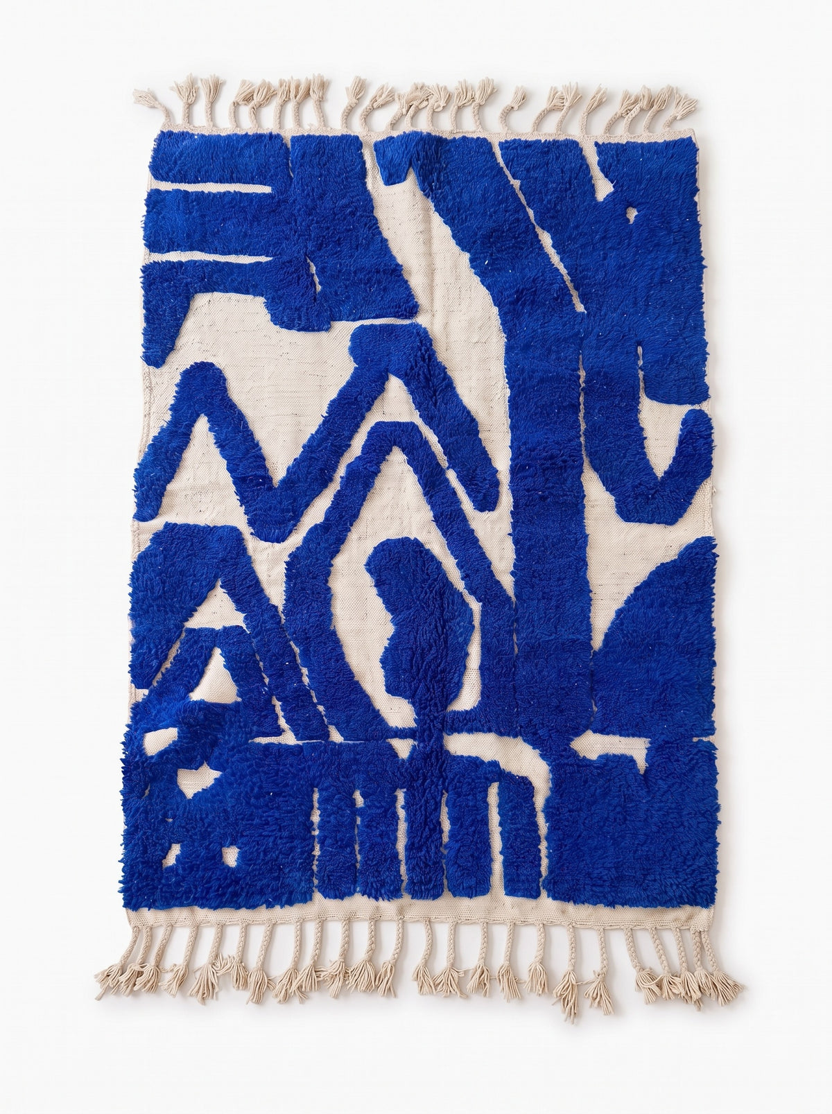 Tapis berbère graphique bleu roi Loukkos vu à plat, fond écru ras, symboles bleu roi en relief, franges écrues tressées à pompons