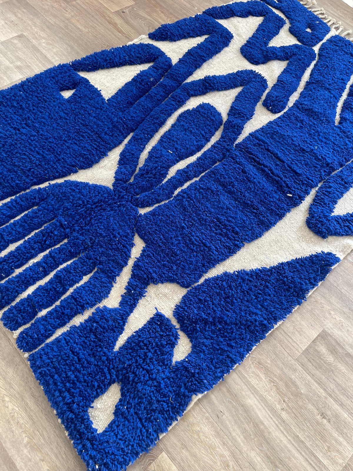 Gros plan sur un détail du tapis berbère Martil, poil long et motif bleu roi vus de près