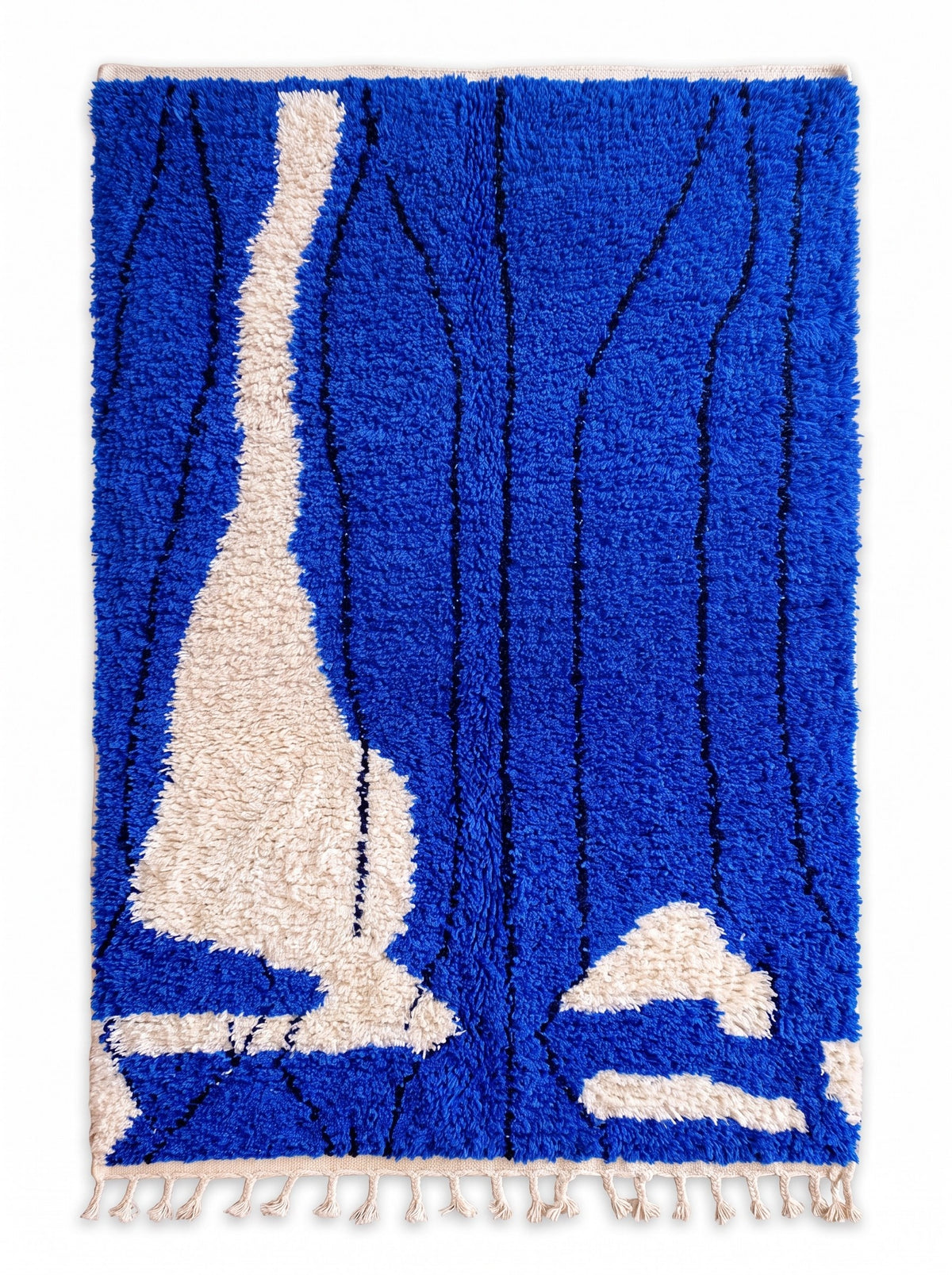 Tapis berbère graphique bleu roi Tizgane vu à plat, fond bleu roi vif à poil long, franges écrues tressées en bas