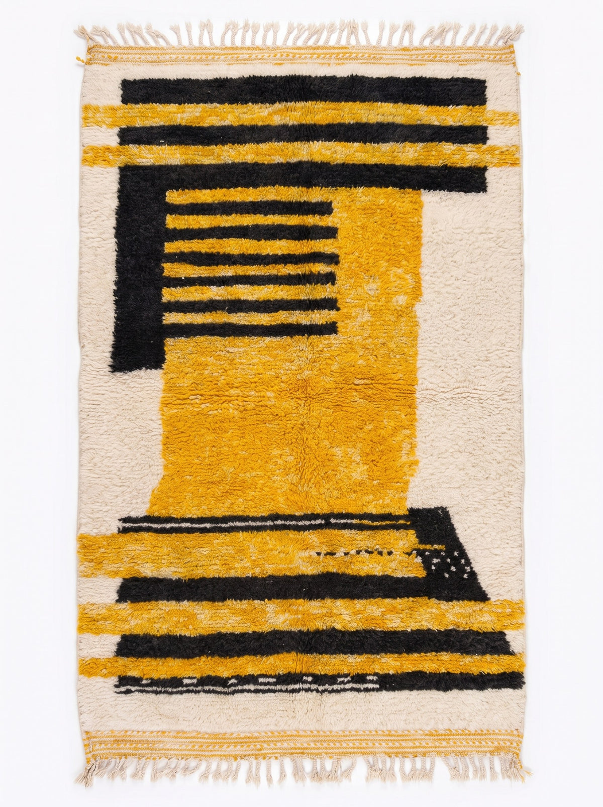 Tapis berbère graphique jaune et noir Zandir vu à plat, fond écru à poil long, bandes noires et moutarde, franges écrues courtes