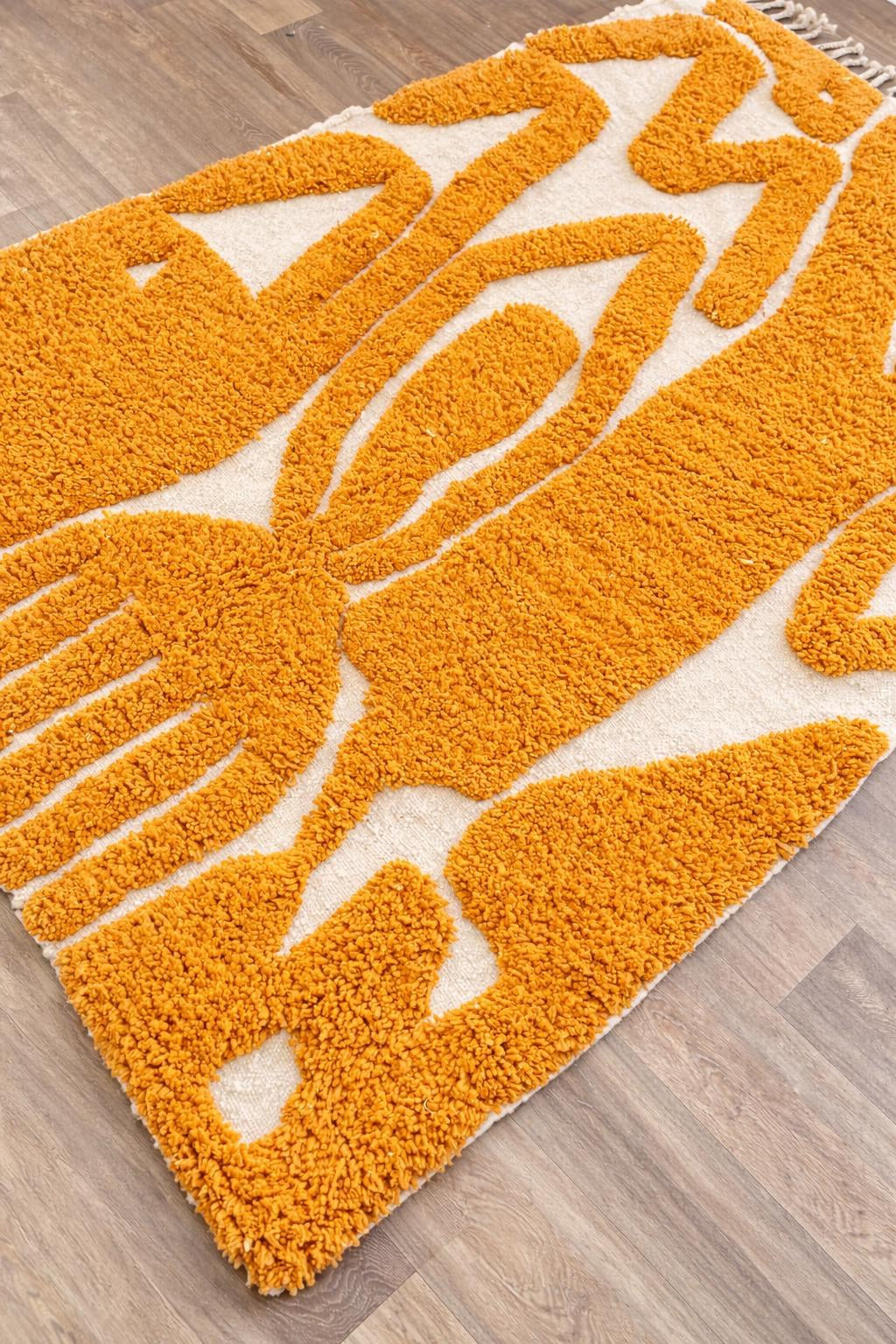 Gros plan sur un détail du tapis berbère Aridal, poil long et motif moutarde vus de près